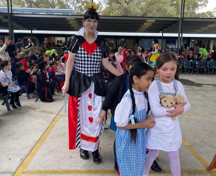 A teacher and two students dressed up as costume characters for a book parade