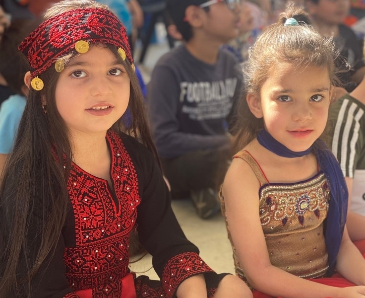 Two young girls wearing cultural clothing for multicultural day