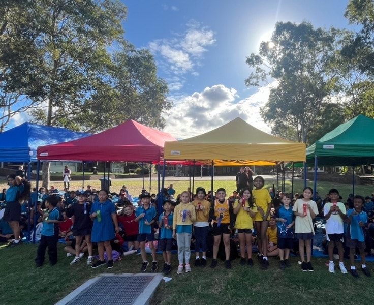 A large crowd of students in their house colours at a cross country carnival.